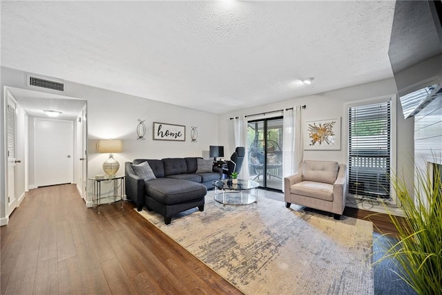 living room with a textured ceiling and hardwood / wood-style flooring