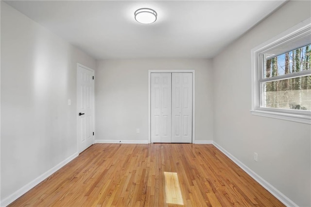 unfurnished bedroom with a closet and light hardwood / wood-style flooring