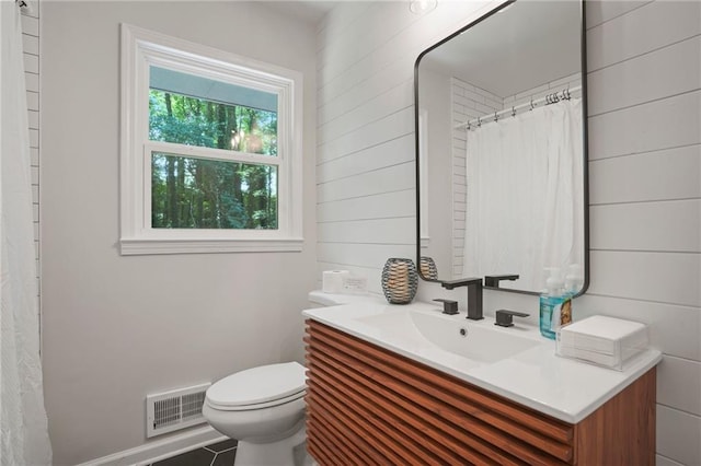 bathroom with toilet, vanity, tile patterned flooring, and curtained shower