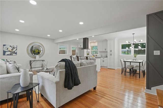 living room featuring light wood-type flooring and a chandelier