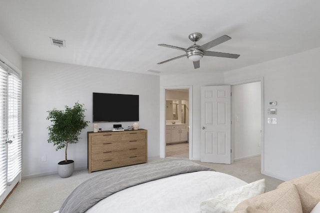 carpeted bedroom with ensuite bathroom and ceiling fan