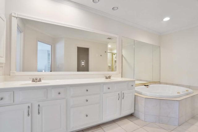 bathroom with tile patterned floors, crown molding, tiled tub, and vanity