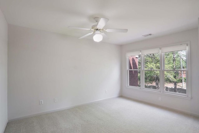 carpeted spare room featuring ceiling fan