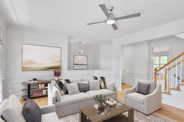 living room featuring ceiling fan, light hardwood / wood-style flooring, and crown molding