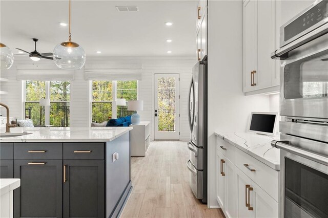 228 Idylwilde Way, Canton, GA 30115 - kitchen featuring visible vents, white cabinets, decorative light fixtures, stainless steel appliances, and light wood-style flooring