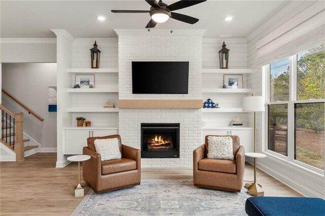 228 Idylwilde Way, Canton, GA 30115 - sitting room featuring crown molding, a fireplace, a ceiling fan, wood finished floors, and stairs
