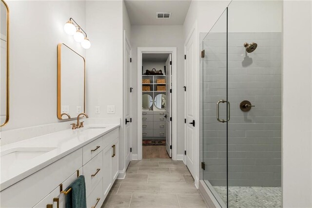 228 Idylwilde Way, Canton, GA 30115 - full bath with visible vents, a sink, a spacious closet, a shower stall, and double vanity