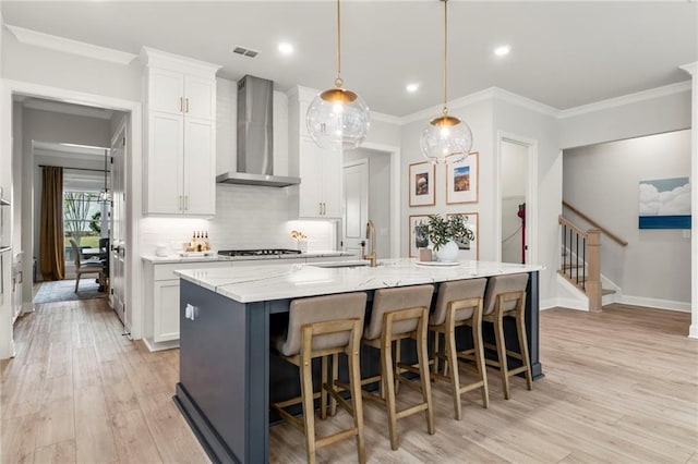 228 Idylwilde Way, Canton, GA 30115 - kitchen with visible vents, white cabinets, wall chimney range hood, light wood-style floors, and backsplash