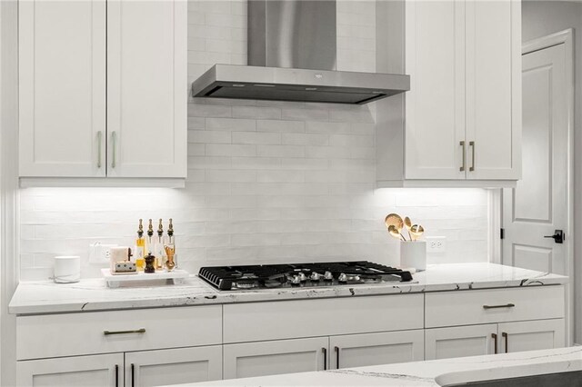 228 Idylwilde Way, Canton, GA 30115 - kitchen with light stone counters, wall chimney range hood, white cabinetry, backsplash, and stainless steel gas cooktop