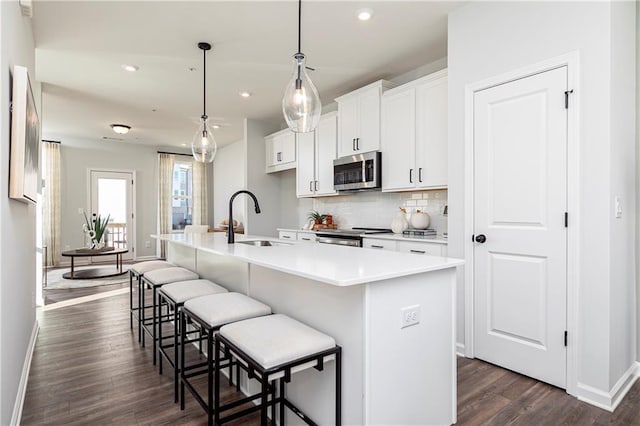 339 Skylar Way SE, Atlanta, GA 30315 - kitchen with stainless steel appliances, a sink, a center island with sink, baseboards, and dark wood finished floors