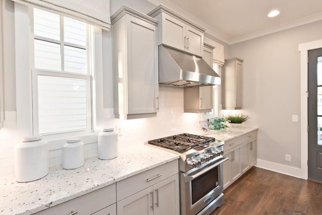 kitchen with high end stainless steel range oven, gray cabinets, dark wood-type flooring, light stone countertops, and crown molding