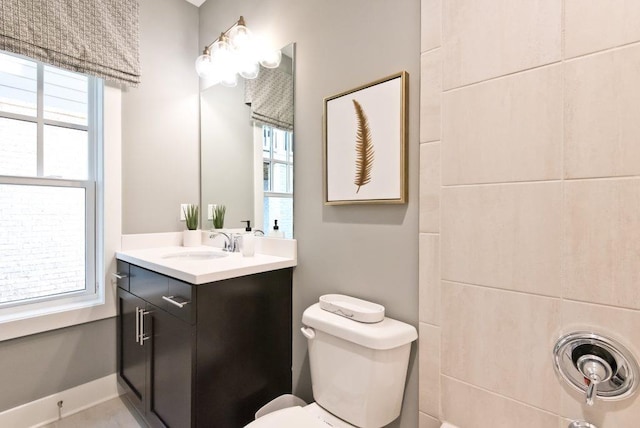 bathroom featuring a wealth of natural light, toilet, and vanity