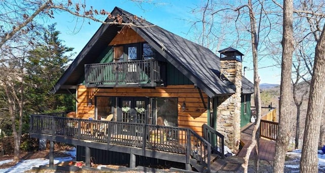 view of front of house with board and batten siding, roof with shingles, and a chimney