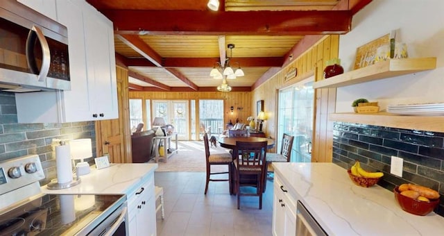 kitchen with tasteful backsplash, white cabinetry, stainless steel appliances, and beam ceiling