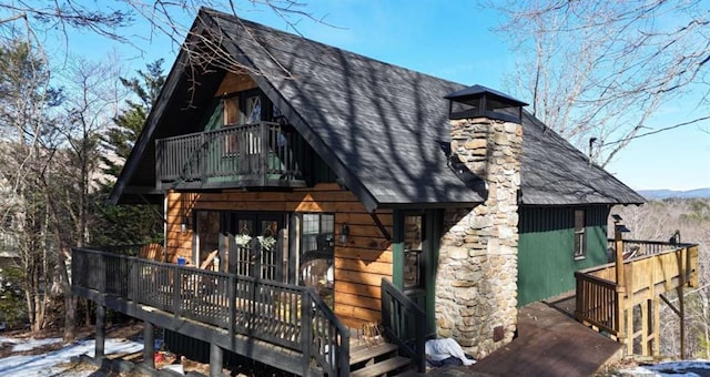 view of front of home with a balcony, a shingled roof, and french doors