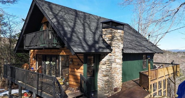 exterior space with french doors and roof with shingles