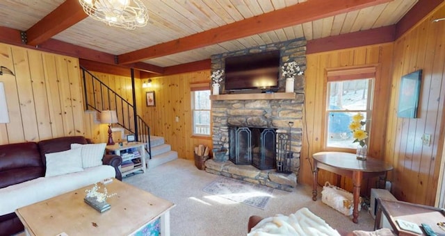 living area featuring wooden walls, stairs, and beamed ceiling