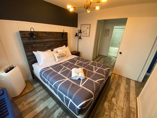 bedroom with dark wood-type flooring and a notable chandelier