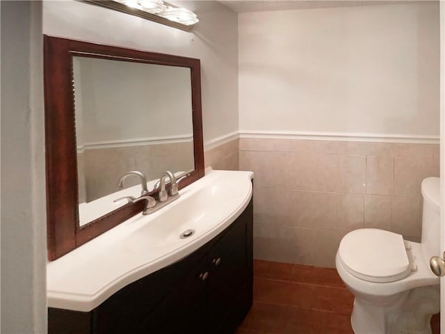 bathroom featuring tile patterned floors, vanity, tile walls, and toilet