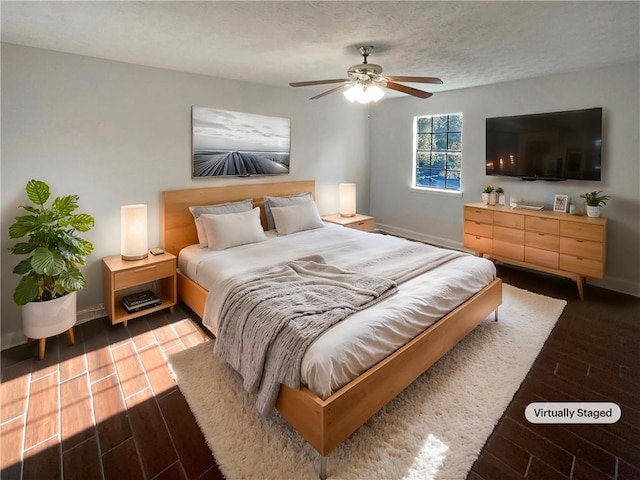 bedroom featuring hardwood / wood-style floors, ceiling fan, and a textured ceiling