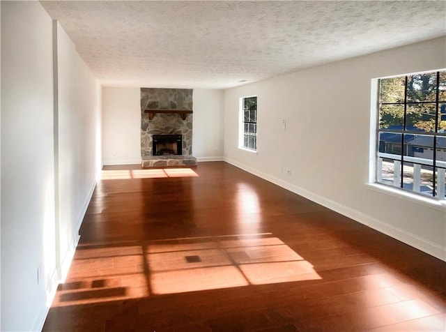 unfurnished living room featuring hardwood / wood-style flooring, a fireplace, and a textured ceiling