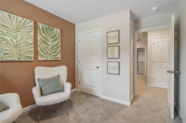 sitting room featuring light carpet