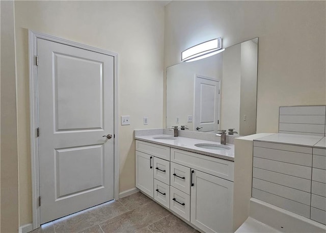 bathroom featuring double vanity, baseboards, and a high ceiling