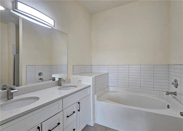 bathroom featuring double vanity, a bath, and tile patterned flooring