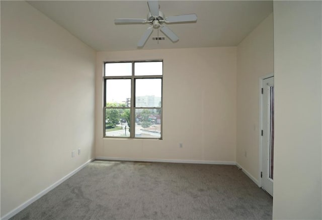 spare room with carpet flooring, a ceiling fan, and baseboards