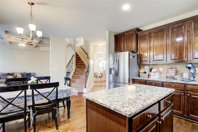 3746 Okefenokee Rdg, Loganville, GA 30052 - kitchen with stainless steel fridge with ice dispenser, arched walkways, wood finished floors, a ceiling fan, and decorative backsplash