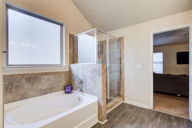3746 Okefenokee Rdg, Loganville, GA 30052 - bathroom featuring a bath, wood finished floors, a shower stall, and baseboards