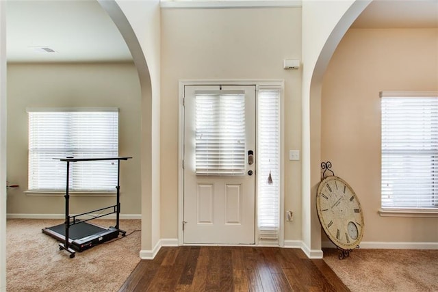 3746 Okefenokee Rdg, Loganville, GA 30052 - entrance foyer featuring arched walkways, baseboards, and dark wood finished floors