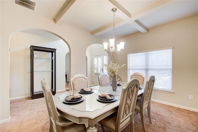 3746 Okefenokee Rdg, Loganville, GA 30052 - dining space featuring light colored carpet, a chandelier, beam ceiling, arched walkways, and baseboards