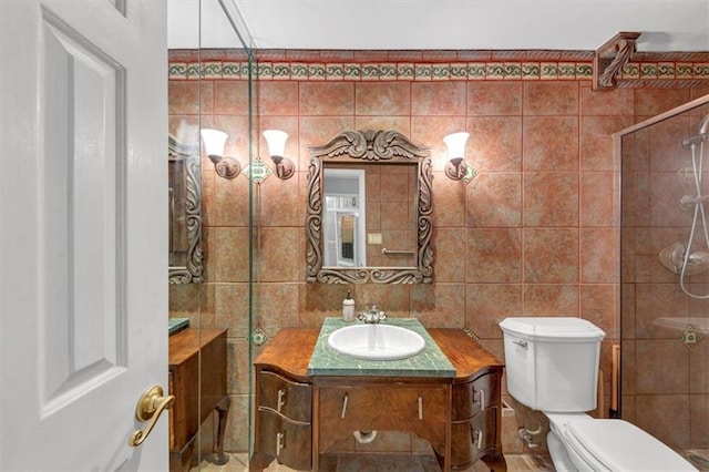 bathroom featuring vanity, toilet, and tile walls