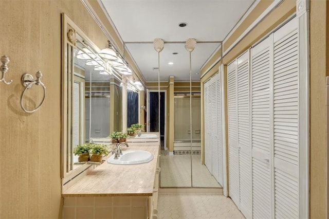 bathroom with tile patterned floors, ornamental molding, and vanity