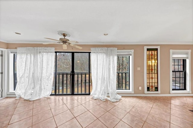 tiled spare room featuring baseboards, ornamental molding, and a ceiling fan