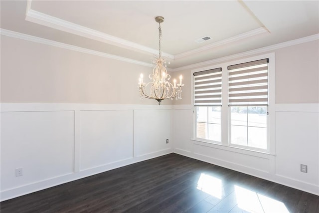 unfurnished dining area featuring crown molding, a tray ceiling, dark wood-type flooring, and a chandelier