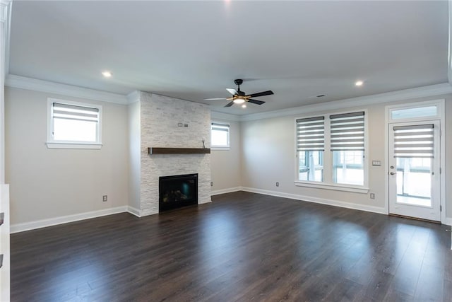 unfurnished living room featuring dark hardwood / wood-style flooring, a stone fireplace, ornamental molding, and ceiling fan