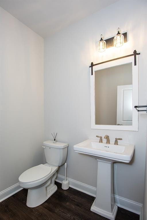 bathroom featuring hardwood / wood-style floors and toilet