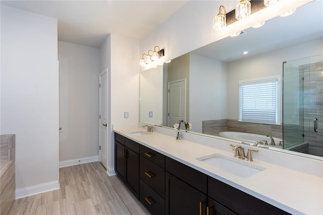 bathroom with vanity, shower with separate bathtub, and hardwood / wood-style floors