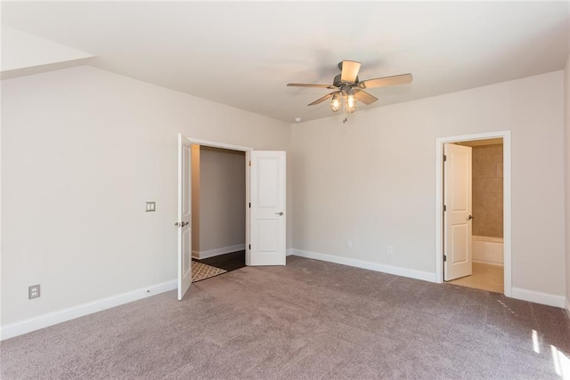 unfurnished bedroom featuring ceiling fan, light carpet, and ensuite bath