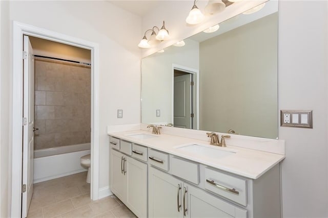 full bathroom featuring tiled shower / bath, vanity, toilet, and tile patterned flooring