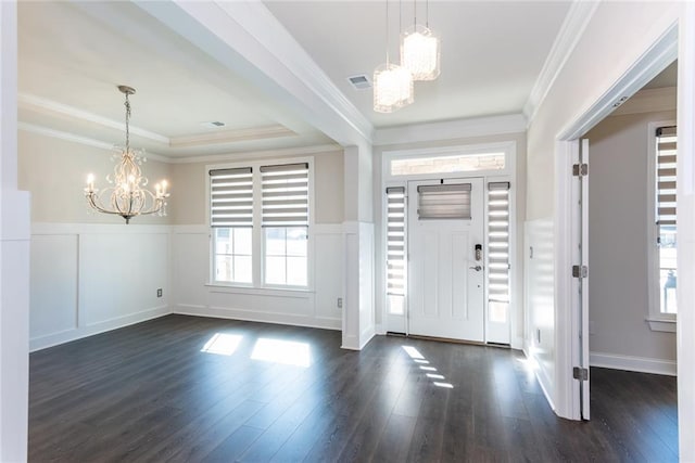 foyer with crown molding, a tray ceiling, dark hardwood / wood-style floors, and a chandelier