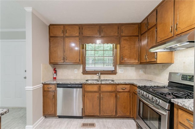 803 Cedar Lake Dr SE, Conyers, GA 30094 - kitchen featuring appliances with stainless steel finishes, a sink, under cabinet range hood, ornamental molding, and light wood finished floors