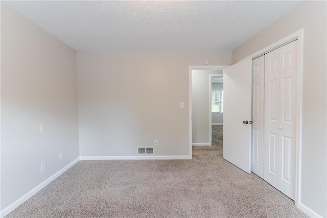 803 Cedar Lake Dr SE, Conyers, GA 30094 - unfurnished bedroom with light carpet, baseboards, a closet, and a textured ceiling