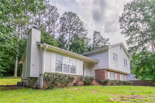 803 Cedar Lake Dr SE, Conyers, GA 30094 - split level home with a chimney, a front yard, brick siding, and central AC unit