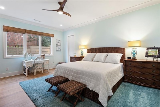 bedroom with light hardwood / wood-style floors, ceiling fan, and ornamental molding