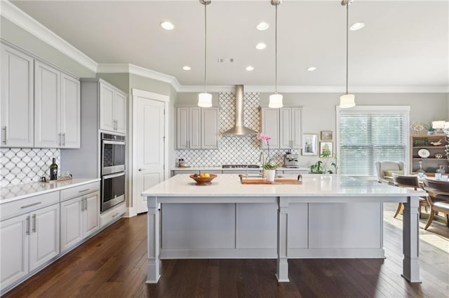 kitchen with a breakfast bar, decorative backsplash, wall chimney exhaust hood, and double oven