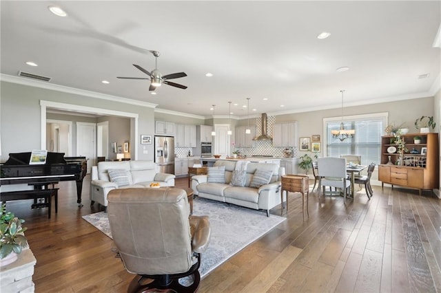 living area featuring recessed lighting, visible vents, hardwood / wood-style flooring, and ceiling fan with notable chandelier