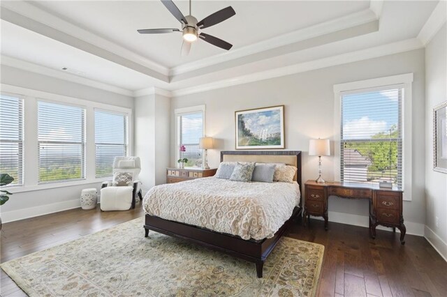 bedroom featuring crown molding, a raised ceiling, a ceiling fan, and dark wood-type flooring